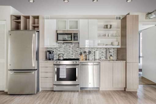 A modern kitchen with a refrigerator, oven, and microwave.at Sky Central, Cincinnati Ohio