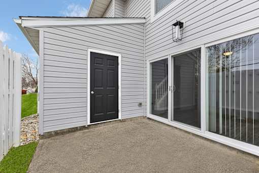 A house with a black door and a white fence.