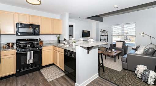 A kitchen with black appliances and wooden cabinets.