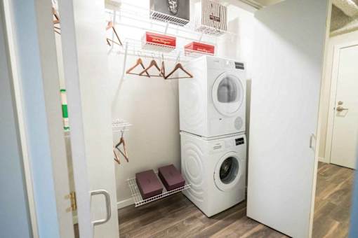 A small laundry room with a washer and dryer stacked on top of each other.at Sky Central, Cincinnati, 45202