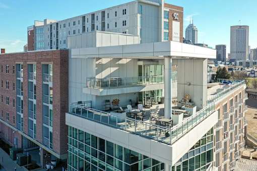 A modern building with a glass balcony overlooking a cityscape.