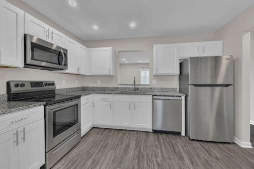 A modern kitchen with stainless steel appliances and white cabinets.