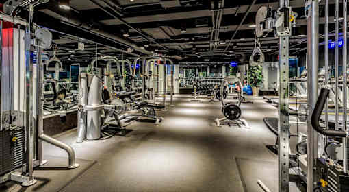 A gym with a variety of equipment including treadmills, weights, and exercise machines.
