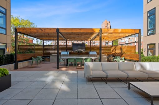 a patio with couches and a table and a tv at Four23/Hoge, Cincinnati, OH