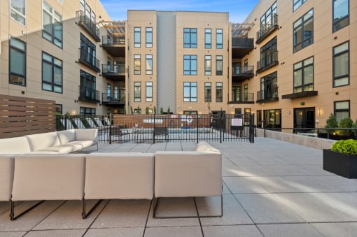 an outdoor patio with couches and chairs in front of an apartment building at Four23/Hoge, Cincinnati
