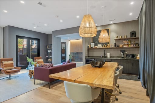 a dining area with a wooden table and chairs and a kitchen in the background at Four23/Hoge, Ohio