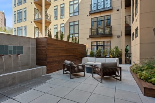 an outdoor patio with couches and chairs in front of an apartment building at Four23/Hoge, Ohio, 45226
