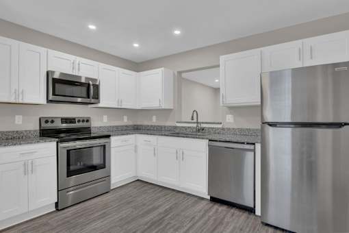 modern kitchen with white cabinets and stainless steel appliances