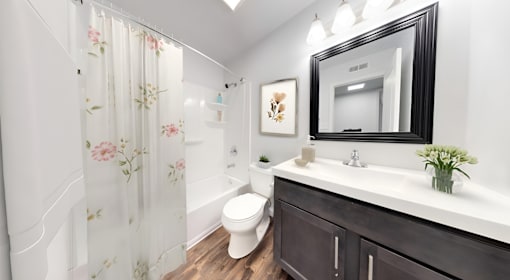 a bathroom with a toilet sink and shower and a mirror at Lawrence Landing, Indianapolis