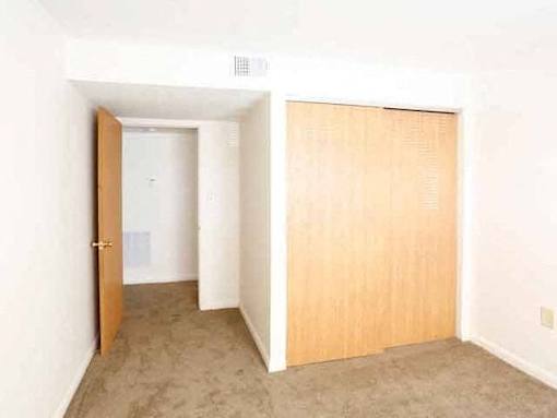 A room with a brown door and a white wall.
