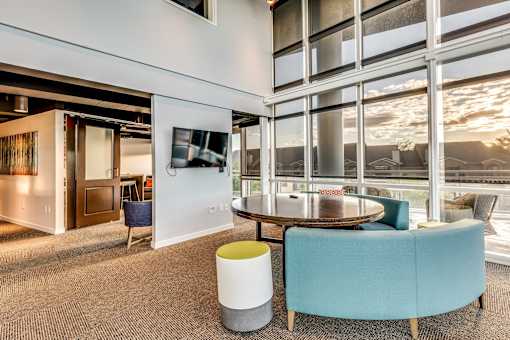 A modern office space with a large table and chairs.