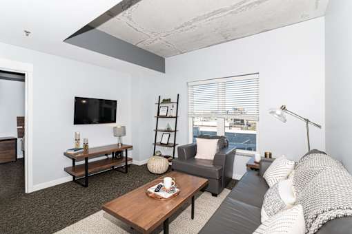 A living room with a grey couch and a wooden coffee table.