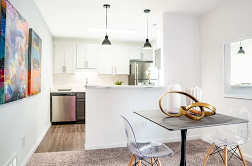 a dining area with a table and chairs and a kitchen in the background at Ten31, Dayton, Ohio