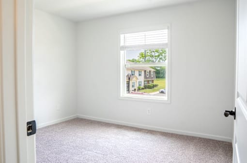 a bedroom with a large window and a carpeted floor at Ten31, Dayton, Ohio