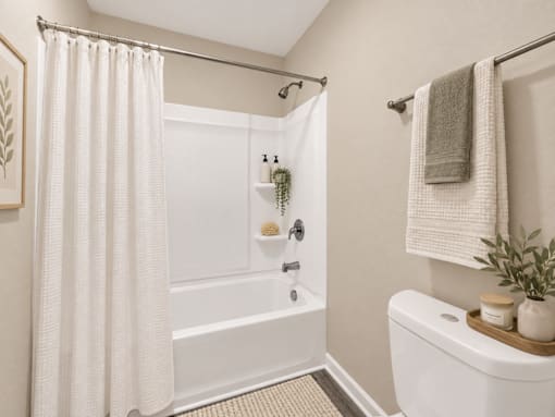 A white bathroom with a shower curtain and a towel hanging on the towel rack.