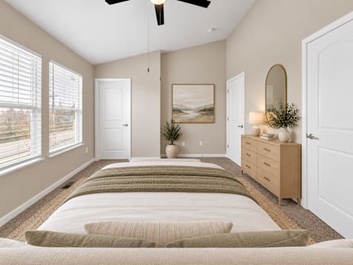 A bedroom with a long bed and a ceiling fan.