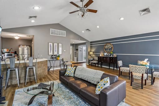 A living room with a grey couch and a ceiling fan.