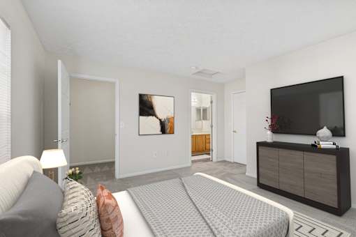 A modern living room with a grey sofa and a grey patterned bedspread.