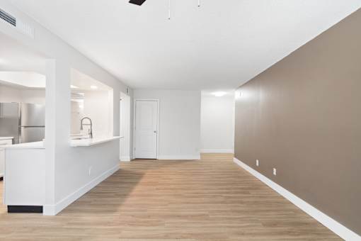 A room with a white kitchen area and a wooden floor.at Crooked Creek, Indianapolis