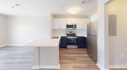 A kitchen with a refrigerator, oven, and microwave.