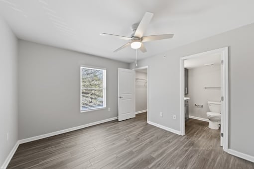 A room with a ceiling fan and a framed picture on the wall.