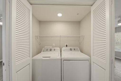 A small bathroom with two sinks and a washer and dryer.