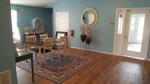 A dining room with a table and chairs.