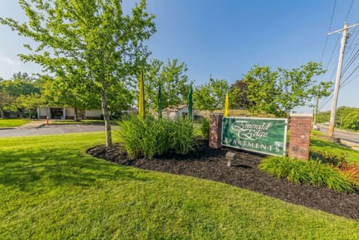 A sign for Elmwood Estates is in front of a green lawn.