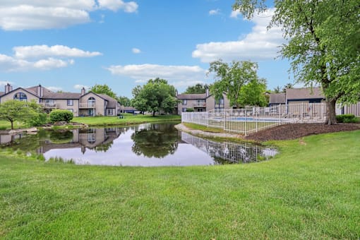 A pond in front of a row of houses.