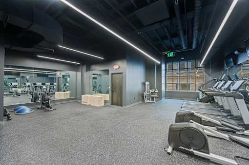 A gym with treadmills, weights, and exercise equipment at Sky Central Apartments, Cincinnati, OH