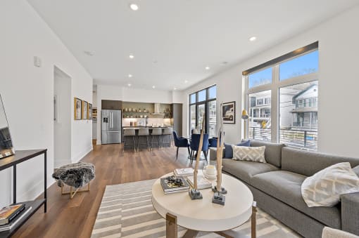 Living area with a couch coffee table and a kitchen in the background at Four23/Hoge, Cincinnati, OH