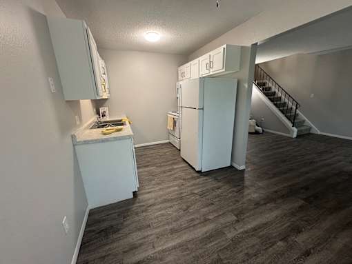 Kitchen with wooden cabinets and a white fridge at Waterfront Pointe, Indianapolis, IN