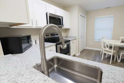 A kitchen with a sink and a microwave.
