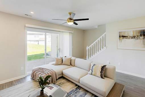 A living room with a white couch and a ceiling fan.