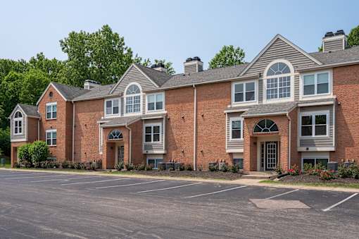 Large brick apartment building with a parking lot at Indian Lookout, 45449