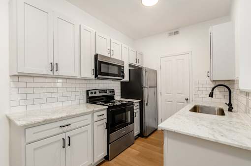 a kitchen with white cabinets and stainless steel appliances at Prescott Place, Columbus, OH