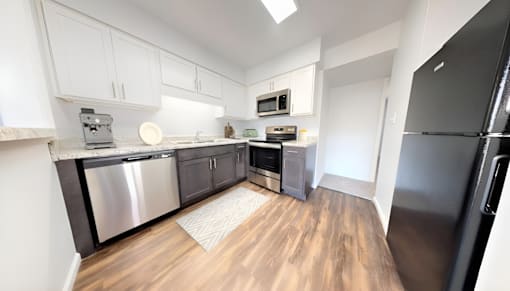 an empty kitchen with stainless steel appliances and white cabinets at Lawrence Landing, Indiana, 46226