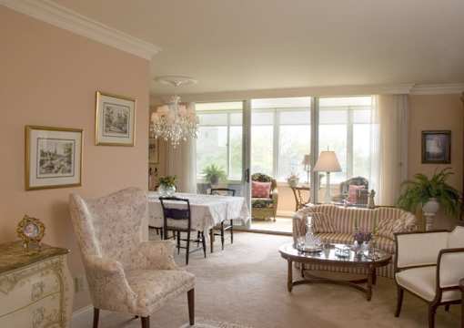 A living room with a chair, a sofa, a coffee table, and a chandelier.