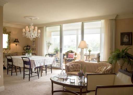 A well-lit living room with a dining table and chairs.