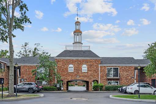 a brick church with a steeple and cars parked in front at Olde Towne in Kenwood, Cincinnati, 45243