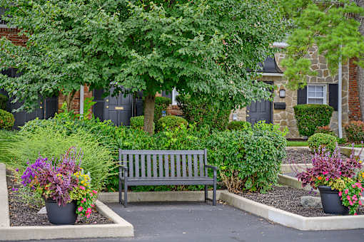 a wooden bench sitting in front of a garden at Olde Towne in Kenwood, Ohio