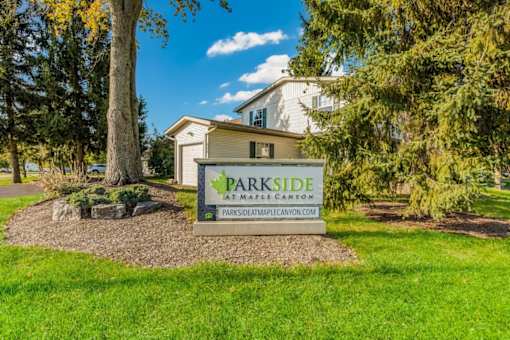 a parkide sign in front of a house with trees at Parkside at Maple Canyon Apartments, Columbus