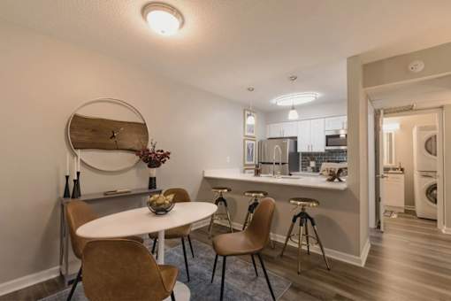A modern kitchen with a dining table and chairs at A62 Apartments, Indianapolis, IN
