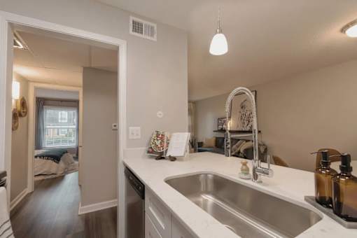 A kitchen with a white countertop and a stainless steel sink at A62 Apartments, Indianapolis 46220