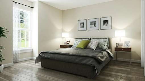 A bedroom with a bed, two lamps, and three pictures on the wall at A62 Apartments, Indianapolis, Indiana