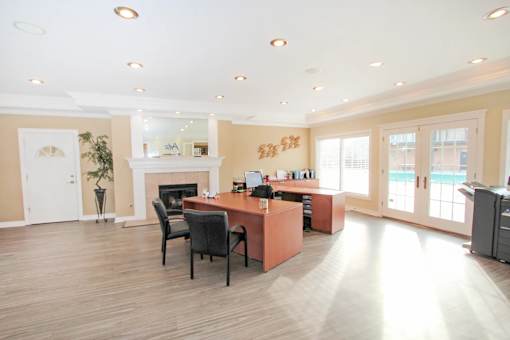 A spacious office with a desk, chairs, and a fireplace at A62 Apartments, Indianapolis, IN