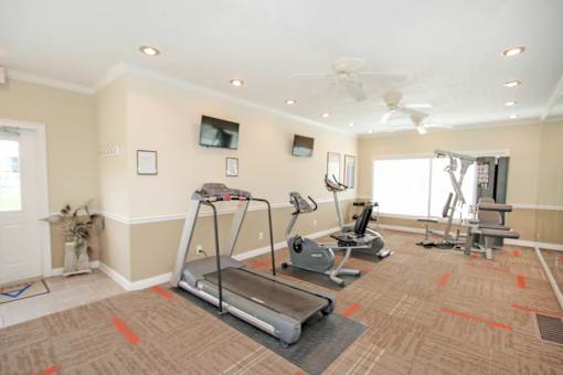 A home gym with a treadmill, exercise bike, and other equipment at A62 Apartments, Indianapolis, IN 46220