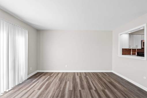 A room with wooden flooring and a large mirror on the wall.