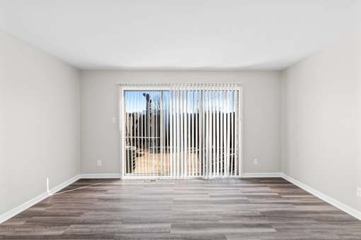 A room with a large window and a wooden floor.