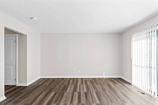 A room with wooden flooring and white walls.